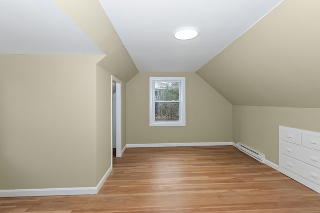 bonus room featuring light wood-style floors, baseboards, baseboard heating, and lofted ceiling