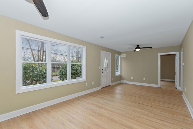 unfurnished living room featuring visible vents, light wood-style flooring, a ceiling fan, and baseboards