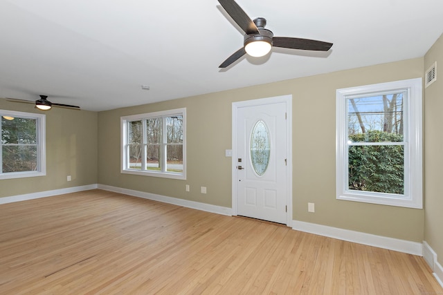 foyer with light wood-style flooring, a healthy amount of sunlight, visible vents, and baseboards