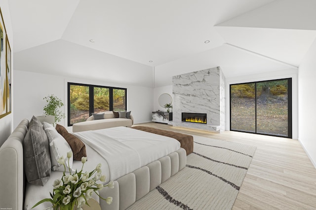 bedroom with lofted ceiling, light wood-type flooring, and a premium fireplace