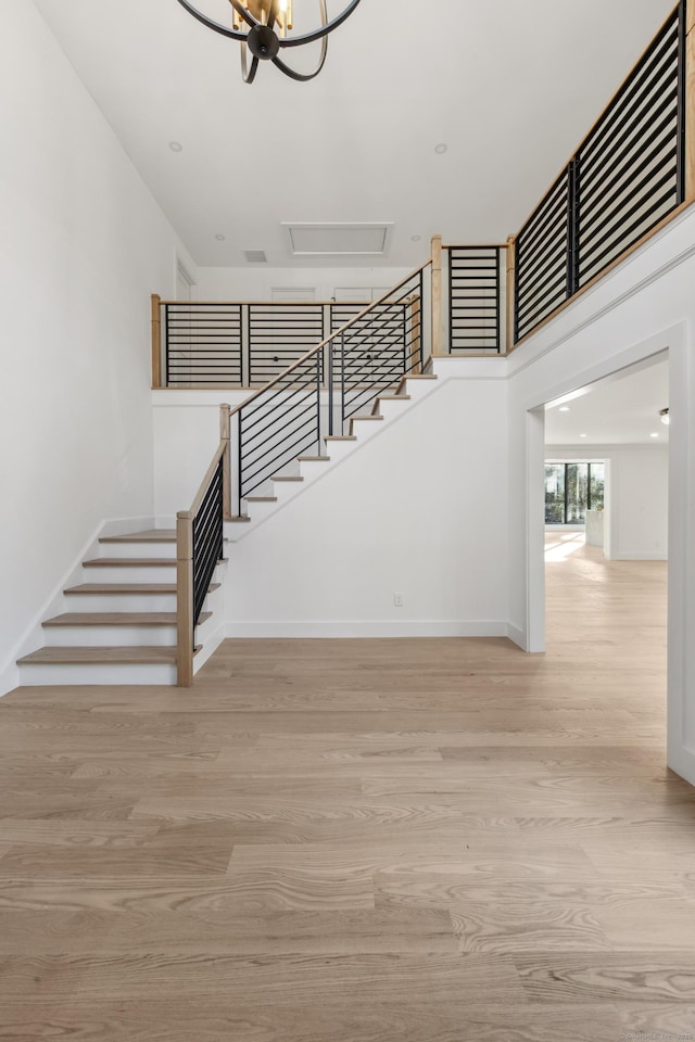 staircase with a chandelier and hardwood / wood-style flooring