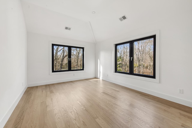 empty room with lofted ceiling, a healthy amount of sunlight, and french doors