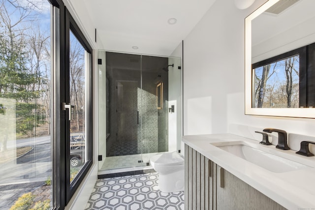 bathroom with a shower with shower door, tile patterned flooring, sink, and toilet