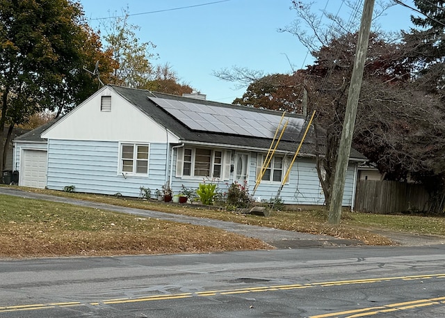 view of front facade with solar panels and a garage