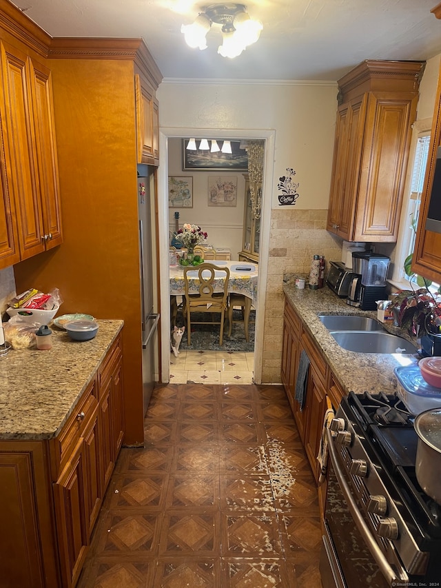 kitchen with appliances with stainless steel finishes, decorative backsplash, light stone countertops, and sink