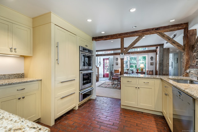 kitchen featuring light stone countertops, sink, french doors, stainless steel appliances, and cream cabinetry