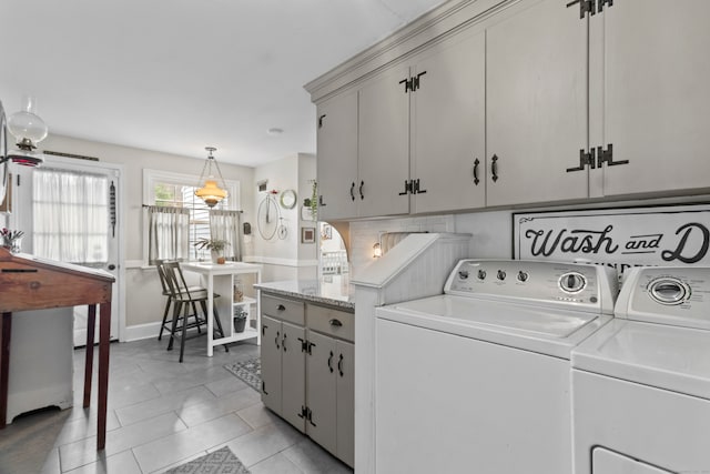 laundry area with washer and clothes dryer, cabinets, and light tile patterned floors