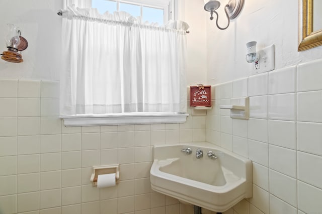 bathroom featuring sink and tile walls