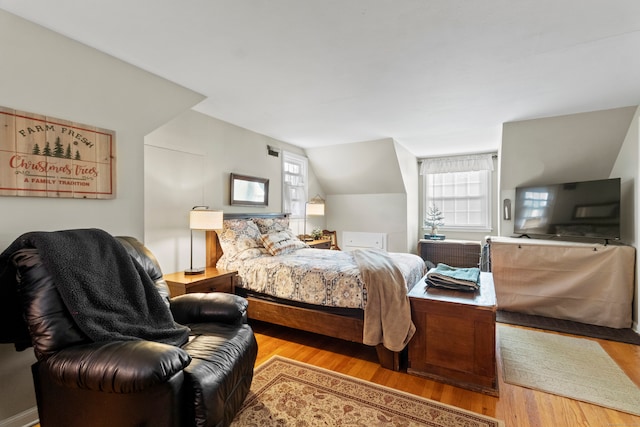 bedroom featuring light wood-type flooring and lofted ceiling