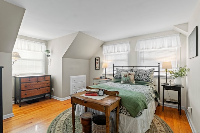 bedroom featuring vaulted ceiling and light hardwood / wood-style floors