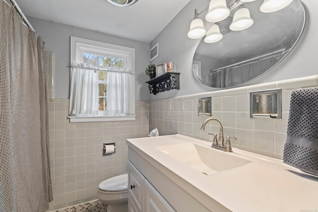 bathroom featuring tile walls, vanity, and toilet