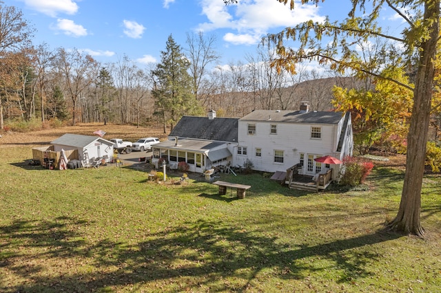 rear view of property with an outbuilding and a yard