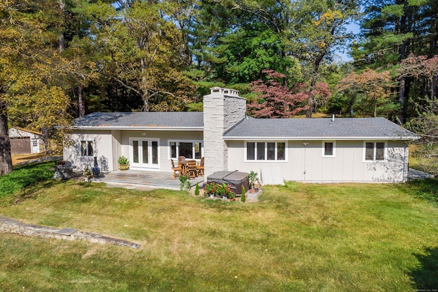 rear view of house featuring a patio area, a yard, a jacuzzi, and french doors