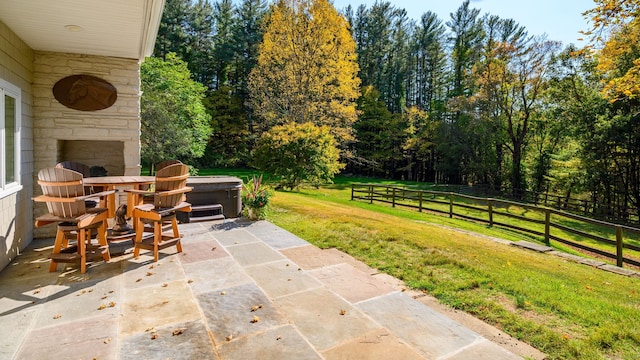 view of patio featuring an outdoor stone fireplace and a hot tub