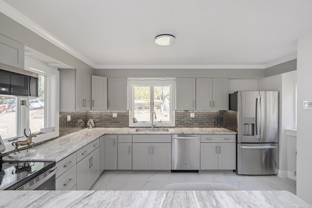 kitchen featuring light stone countertops, appliances with stainless steel finishes, backsplash, and sink