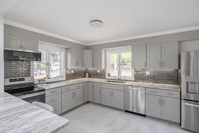 kitchen featuring decorative backsplash, light stone counters, gray cabinetry, and stainless steel appliances