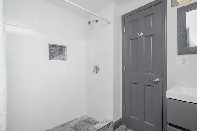 bathroom featuring vanity and tiled shower