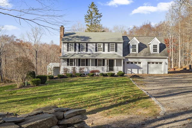 view of front facade featuring a front lawn, covered porch, and a garage