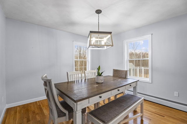 dining area featuring hardwood / wood-style flooring, a chandelier, and a baseboard radiator