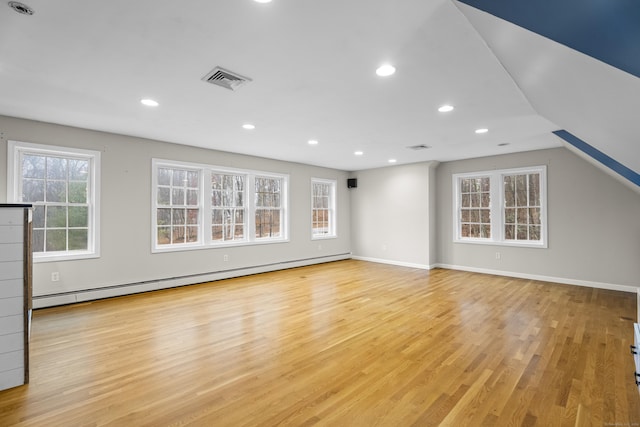 unfurnished living room featuring light hardwood / wood-style floors, vaulted ceiling, and baseboard heating