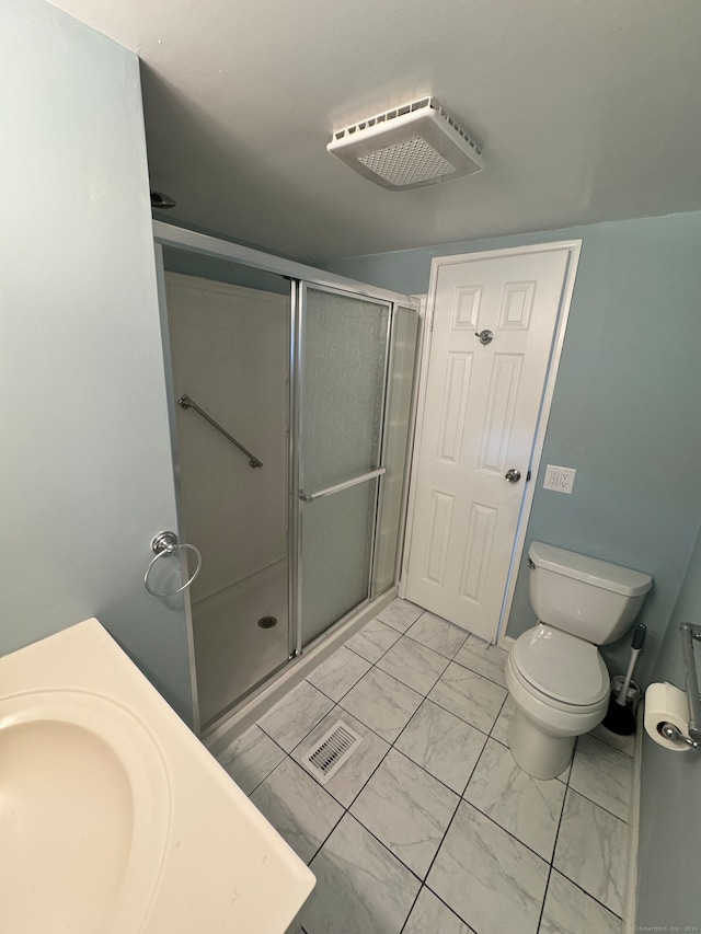 bathroom with sink, toilet, and a shower with shower door