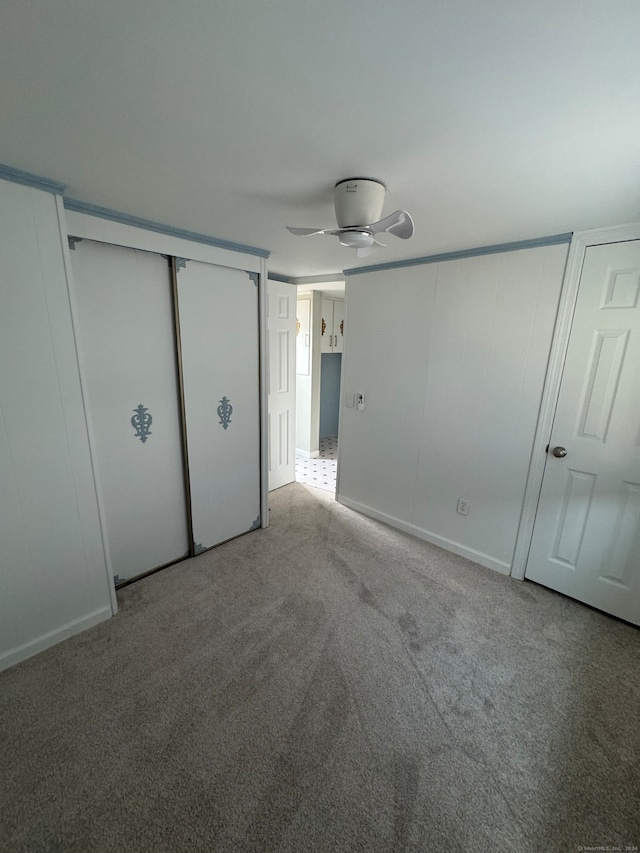 unfurnished bedroom with a closet, ceiling fan, and carpet floors