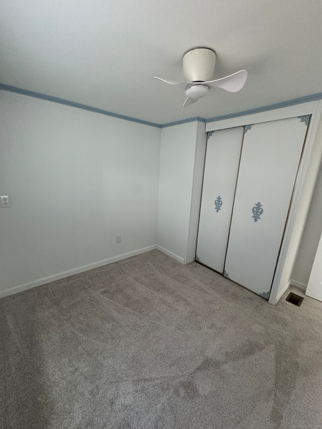 unfurnished bedroom with a closet, light colored carpet, and ceiling fan