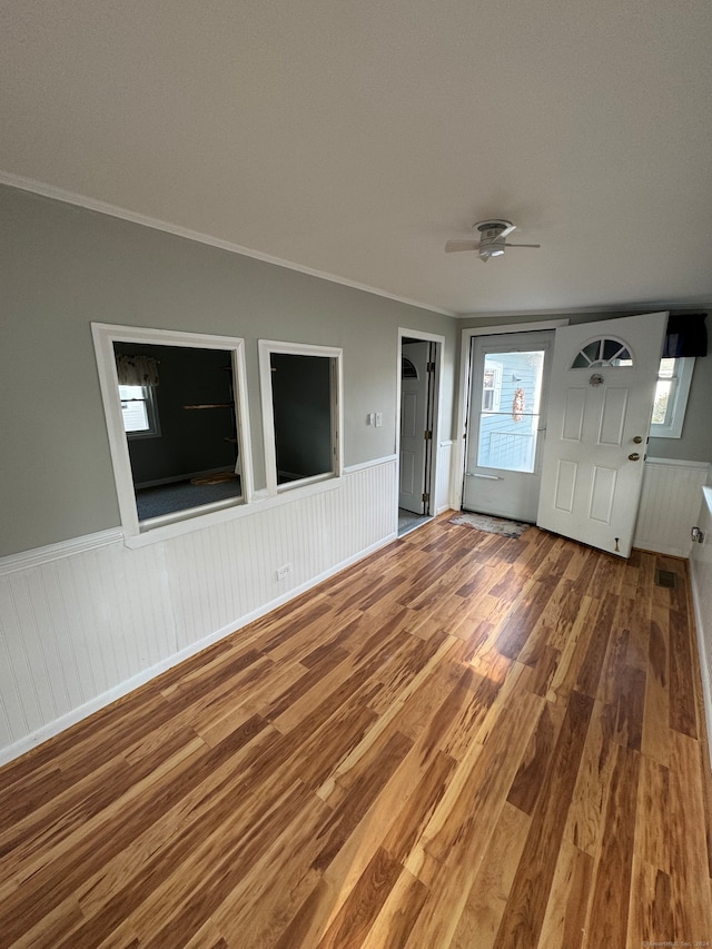 interior space featuring ornamental molding, wood-type flooring, and ceiling fan