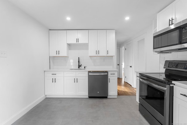 kitchen featuring white cabinets, stainless steel appliances, sink, and backsplash