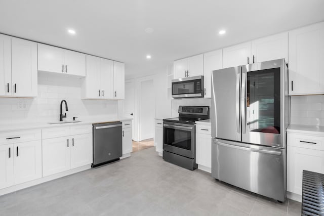 kitchen featuring white cabinetry, appliances with stainless steel finishes, sink, and tasteful backsplash