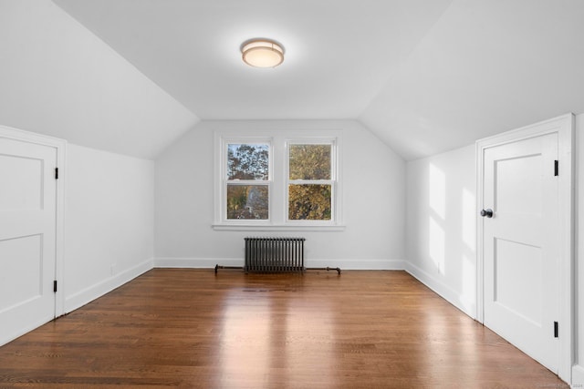 bonus room featuring dark hardwood / wood-style flooring, vaulted ceiling, and radiator