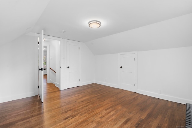 additional living space with vaulted ceiling and dark hardwood / wood-style floors