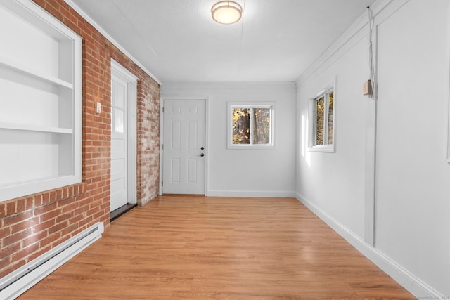 corridor with light hardwood / wood-style floors, built in shelves, baseboard heating, ornamental molding, and brick wall