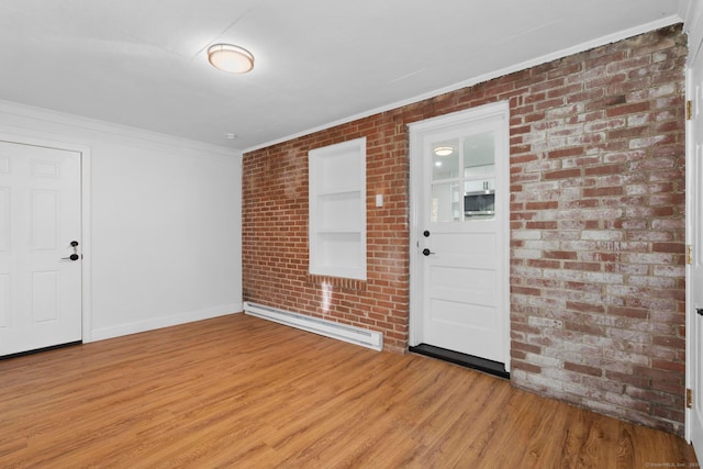 entryway featuring baseboard heating, brick wall, light hardwood / wood-style flooring, and ornamental molding