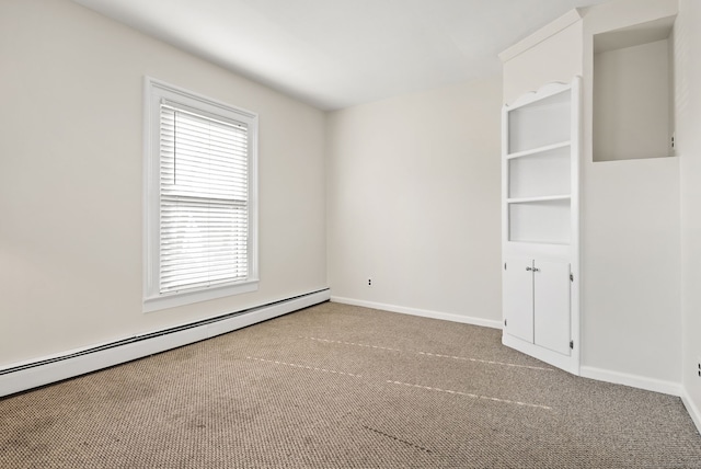 carpeted empty room featuring baseboard heating