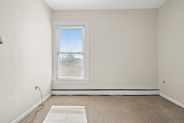 empty room with light carpet, a baseboard radiator, and plenty of natural light