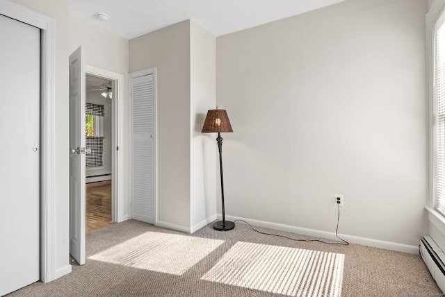 unfurnished bedroom with baseboard heating and light colored carpet