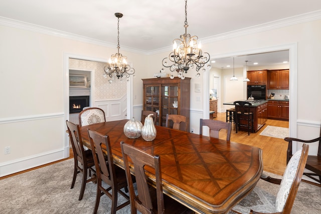 dining room featuring a chandelier, light hardwood / wood-style flooring, and ornamental molding