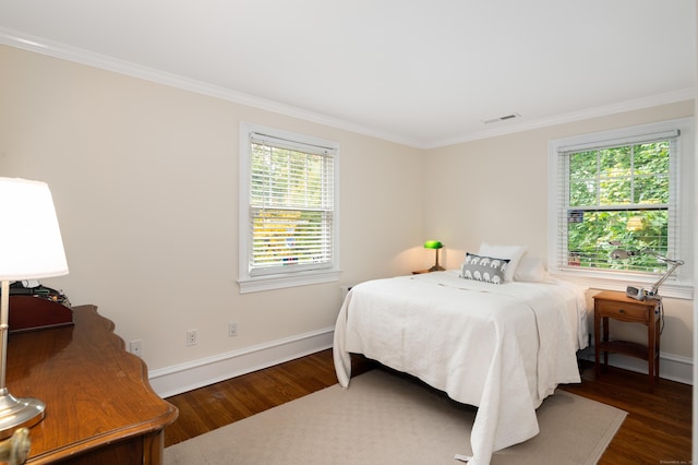 bedroom featuring crown molding and dark wood-type flooring