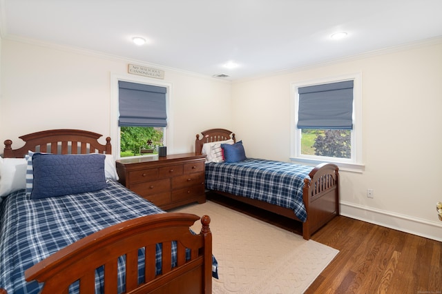 bedroom featuring crown molding and dark wood-type flooring