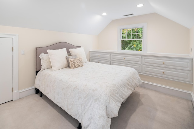 bedroom featuring light colored carpet and lofted ceiling