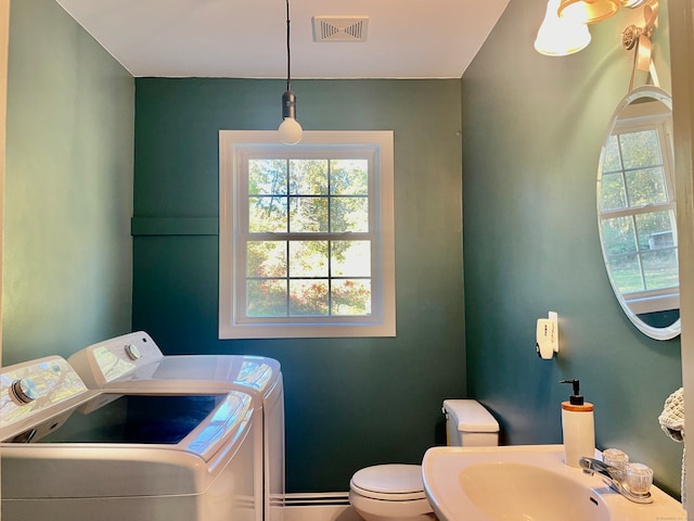 clothes washing area with a wealth of natural light, sink, and washer and clothes dryer