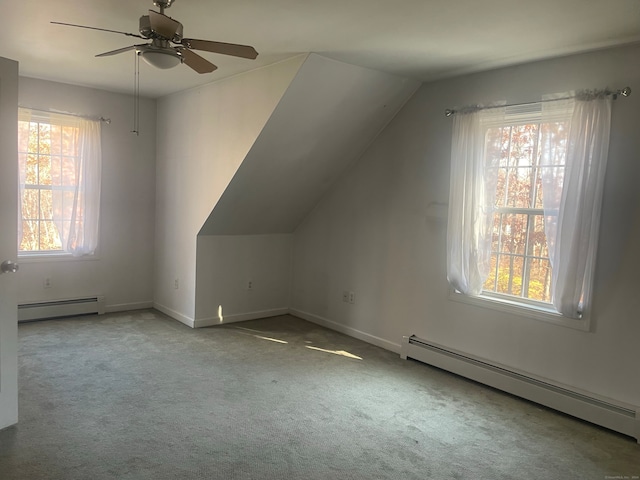 additional living space with a baseboard heating unit, a healthy amount of sunlight, and ceiling fan