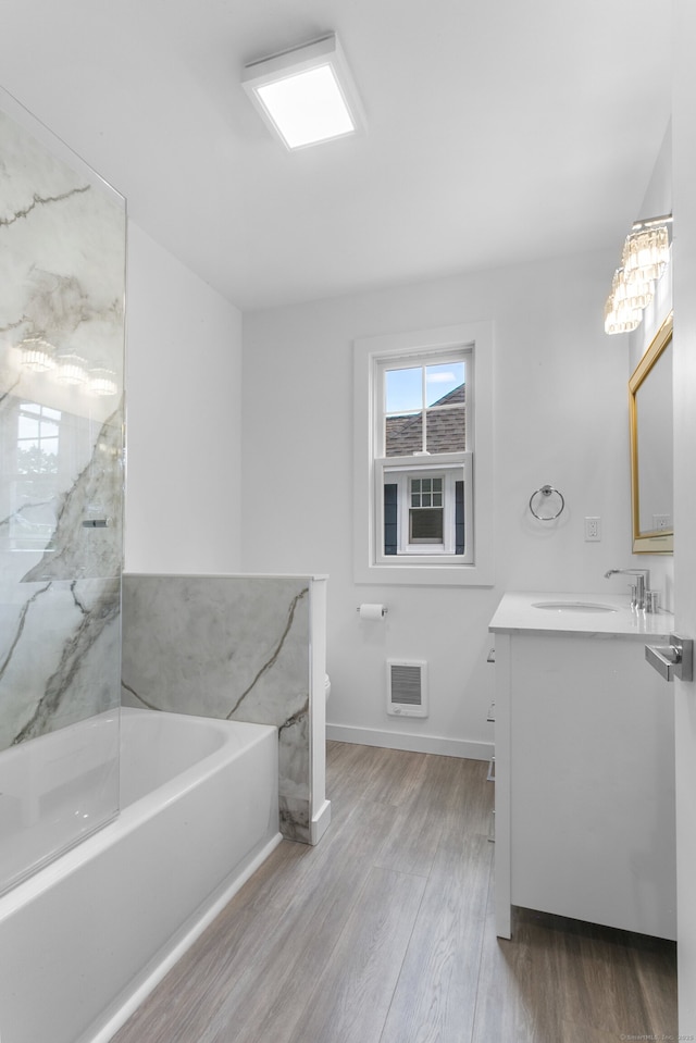 bathroom with hardwood / wood-style floors, vanity, and a bath