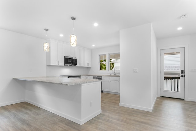 kitchen featuring kitchen peninsula, appliances with stainless steel finishes, sink, pendant lighting, and white cabinetry