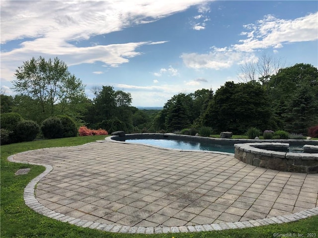 view of pool featuring a patio area and an in ground hot tub