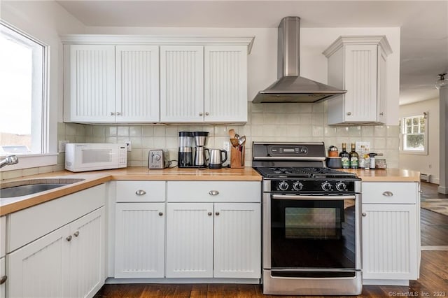 kitchen featuring wall chimney range hood, dark hardwood / wood-style flooring, stainless steel range, and white cabinets