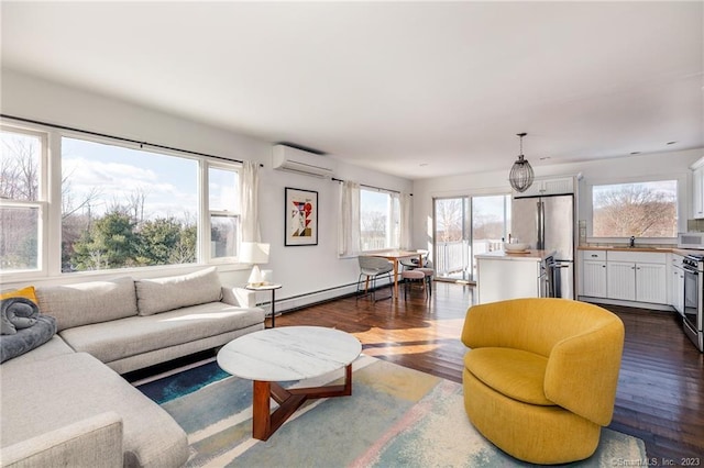 living room with a healthy amount of sunlight, a wall mounted AC, sink, and dark hardwood / wood-style floors