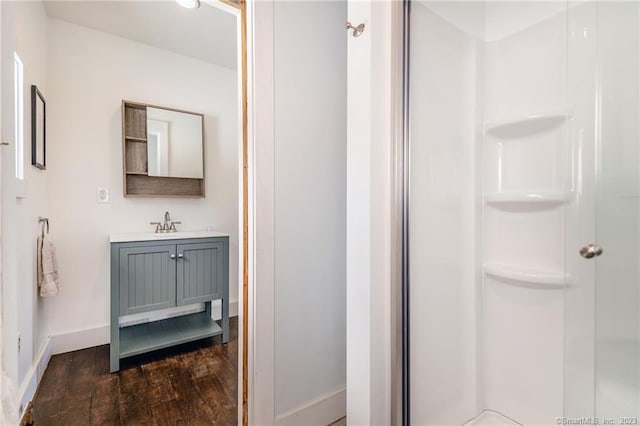 bathroom with a shower with door, vanity, and hardwood / wood-style flooring