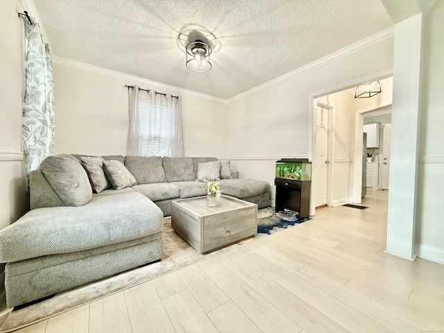 living room with crown molding, a textured ceiling, and light wood-type flooring